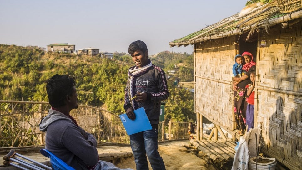 O voluntário rohingya Mohammed Halim (à direita) conversa com Nessar Ahmed no Campo 21, Teknaf, Bangladesh