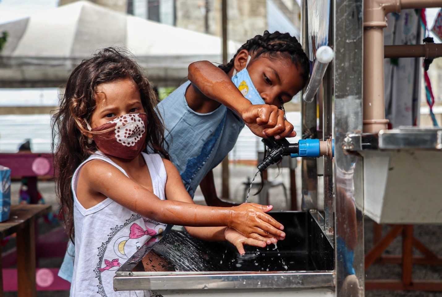 Crianças refugiadas e migrantes venezuelanas higienizam suas mãos durante celebração do Dia Mundial do Refugiado no Espaço Emergencial 13 de Setembro em Boa Vista, Roraima