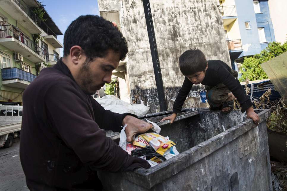 ACNUR - Padre e hijo rebuscan en la basura para alimentar a su familia